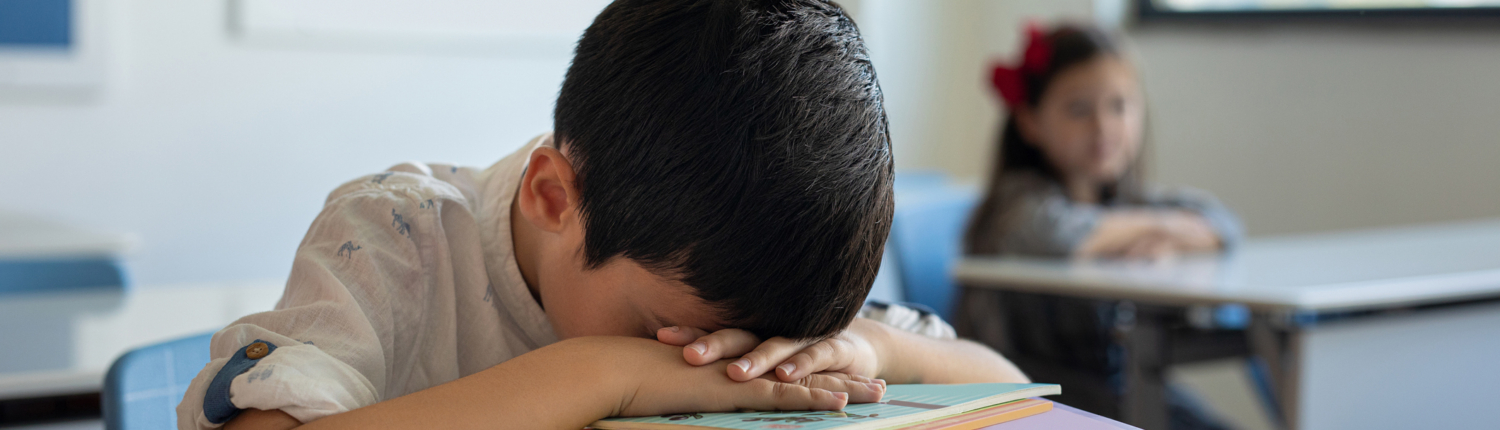 child sleeping at school